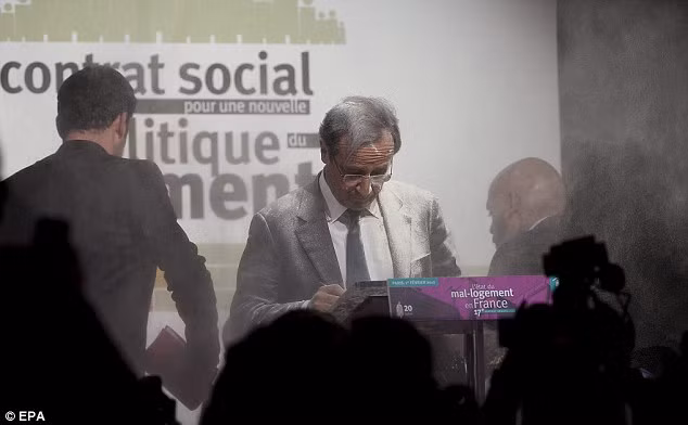 Ông Francois Hollande bình tĩnh tiếp tục bài phát biểu của mình trong lúc người phụ nữ biểu tình bị lực lượng an ninh bắt giữ