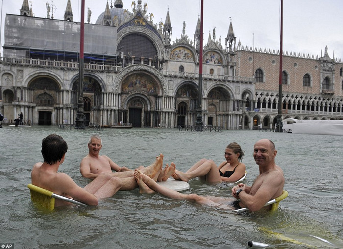 Người dân và khách du lịch tại Venice ngồi trên những chiếc ghế bị ngập nước. Người dân và khách du lịch tại Venice ngồi trên những chiếc ghế bị ngập nước.