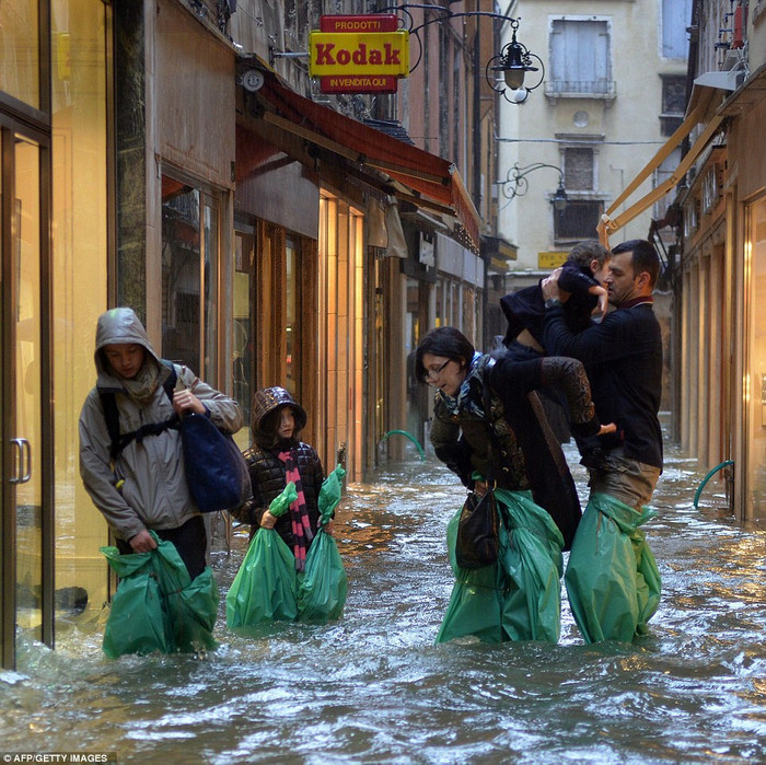 Người dân Venice cố gắng di chuyển trên con phố ngập nước. Người dân Venice cố gắng di chuyển trên con phố ngập nước.