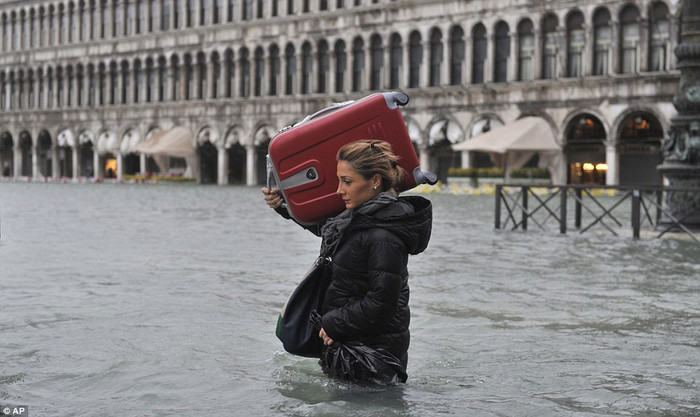 Khách du lịch vác vani lội trong nước tại Venice. Khách du lịch vác vani lội trong nước tại Venice.