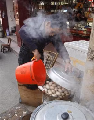 Một người bán trứng đổ xô nước tiểu vào nồi trứng luộc tại cửa hàng bán trứng của mình ở Dongyang ngày 26/3/2012