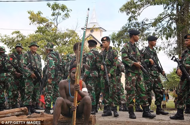 Các binh sĩ Indonesia bao quanh một chiến binh trang bị cung tên.