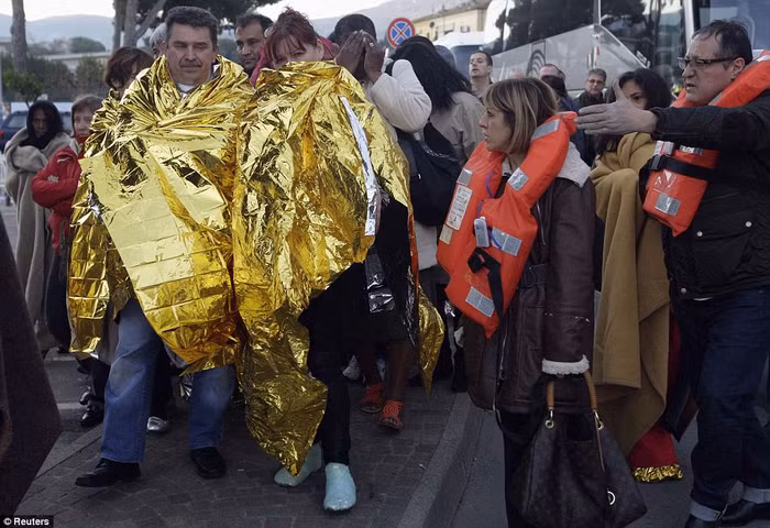 Hành khách trên tàu được các nhân viên cứu hộ giúp đỡ sơ tán lên bờ