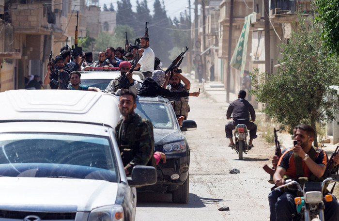 Thành viên của "Tự do cho lữ đoàn sông Assi " của quân đội Syria tự do quay trở lại Qusayr sau một cuộc tấn công nhằm vào lực lượng chính phủ tại làng Nizareer, ngày 12 tháng 5 năm 2012.