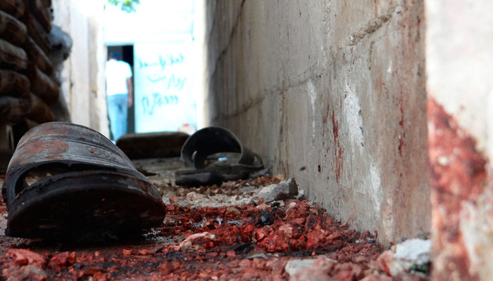 Một đôi dép nằm trên mặt đất đẫm máu sau cuộc pháo kích tại khu vực Talbisah trong thành phố Homs ngày 13/6/2012.