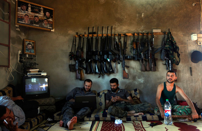 Các tay súng Syria ngồi trong một ngôi nhà tại Aleppo, Syria, ngày 12 tháng 6 năm 2012.