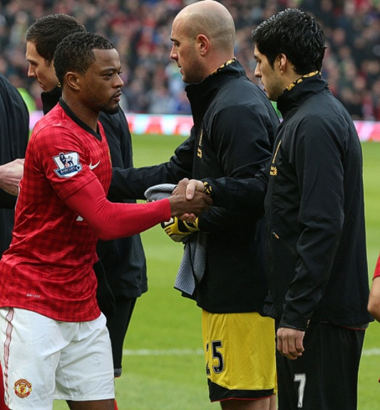 Evra và Suarez bắt tay nhau.