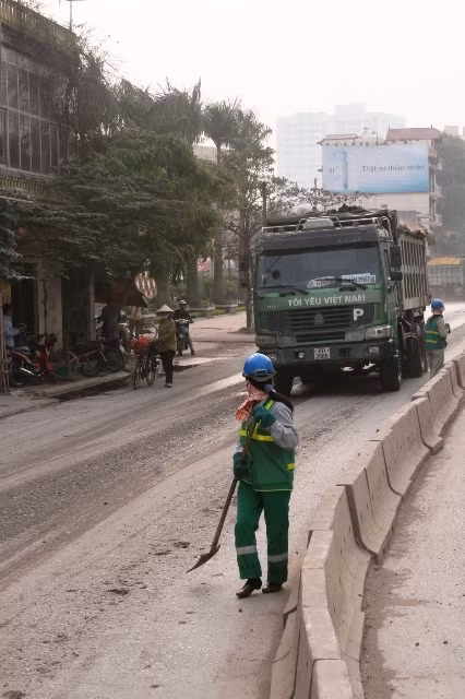 Công nhân Xí nghiệp môi trường 3 dọn không xuể đất cát xe chở đất, cát để lại trên đường
