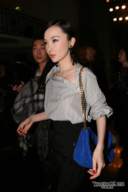 Hoắc Tử Yến diện đồ tây sang trọng cùng chiếc áo sơ mi kẻ sọc cắt ngang không theo quy tắc cùng váy đen dài quá đầu gối. Thiết kế phức tạp mà độc đáo, mang đến sự mới lạ cho người mặc.