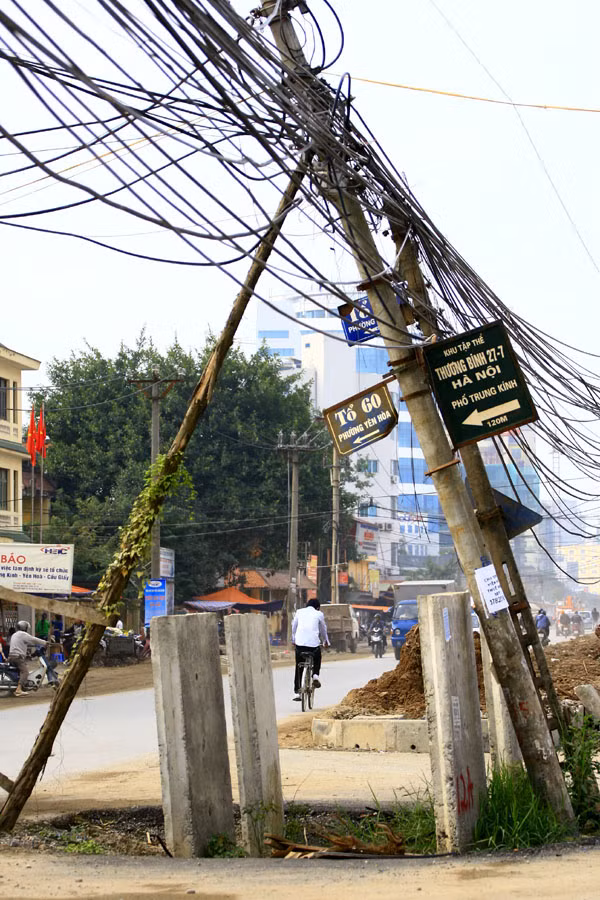 Nhiều chiếc cột điện quá nghiêng được chống tạm sơ sài như thế này... Nhiều chiếc cột điện quá nghiêng được chống tạm sơ sài như thế này...