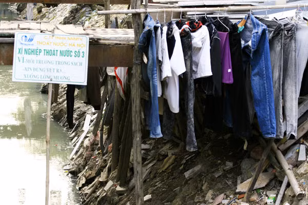 Không có chỗ phơi quần áo, một số người còn tranh thủ phơi luôn trên miệng mương nước đen