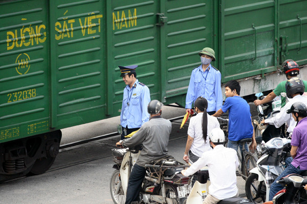 Ở một số đoạn đường, lực lượng nhân viên đường sắt phải ra hiệu lệnh cho người dân dừng lại chờ tàu đi qua Ở một số đoạn đường, lực lượng nhân viên đường sắt phải ra hiệu lệnh cho người dân dừng lại chờ tàu đi qua