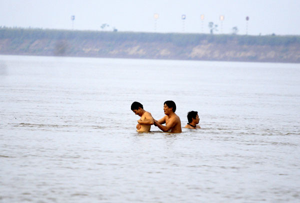 Bên trên là các đôi uyên ương chụp ảnh còn bên dưới lòng sông là những người ưa mạo hiểm, thích tắm sông… tha hồ kì cọ giữa lòng sông Hồng đang chảy xiết Bên trên là các đôi uyên ương chụp ảnh còn bên dưới lòng sông là những người ưa mạo hiểm, thích tắm sông… tha hồ kì cọ giữa lòng sông Hồng đang chảy xiết