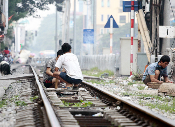 Thản nhiên ngồi hút thuốc lào trên đường ray Thản nhiên ngồi hút thuốc lào trên đường ray