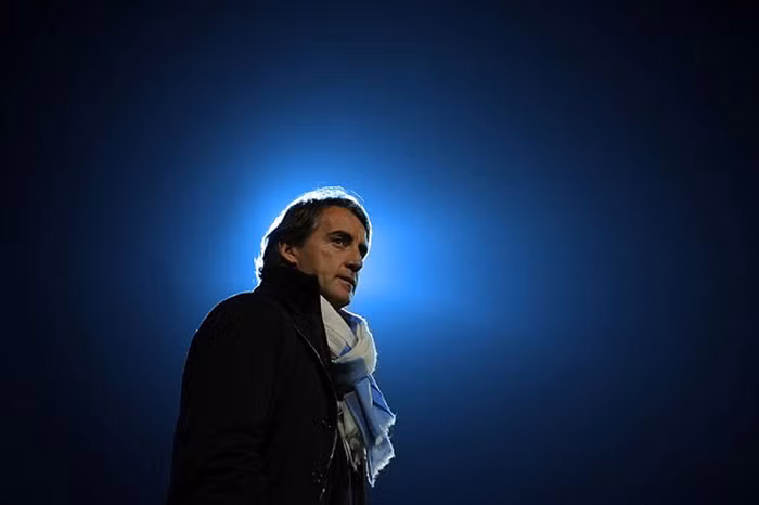 Roberto Mancini đứng bên đường pitch ngắm nhìn các học trò thi đấu trong trận tứ kết Carling Cup giữa Arsenal và Manchester City tại sân Emirates