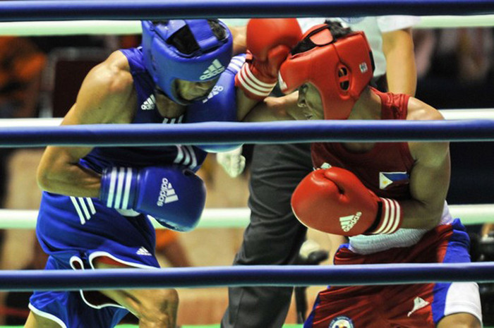 Mark Anthony Barriga (phải) của Philippines đấu với Hitarihun Agust (Indonesia) trong trận tứ kết môn quyền anh ở hạng cân 49kg.