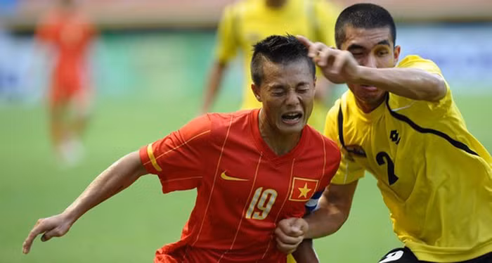 Phạm Thành Lương (trái) tranh bóng với Mohamamad Azri B Zahari (Brunei) trong trận đấu diễn ra ở bảng B bộ môn bóng đá Nam.