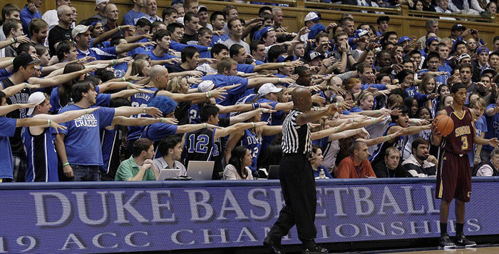 Derrick Hunter (cầm bóng) chuẩn bị phát bóng trong lúc các khán giả của đối thủ đứng sau anh cổ động cho đội nhà tại giải bóng rổ Hiệp hội các trường đại học Quốc gia (Mỹ) Derrick Hunter (cầm bóng) chuẩn bị phát bóng trong lúc các khán giả của đối thủ đứng sau anh cổ động cho đội nhà tại giải bóng rổ Hiệp hội các trường đại học Quốc gia (Mỹ)