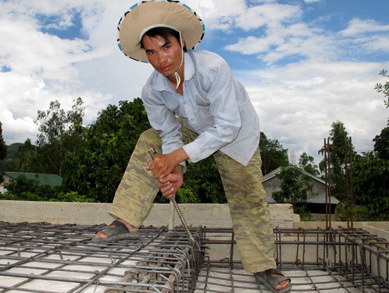 Nguyễn Hùng đang làm phụ hồ tại một công trình xây nhà ở thị trấn A Lưới.