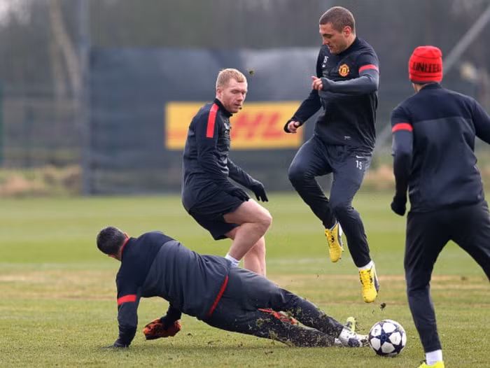 Paul Scholes sẽ không tới Madrid thi đấu vì chấn thương đầu gối, nhưng anh vẫn có mặt để chỉ giáo cho Van Persie cách xoạc bóng.