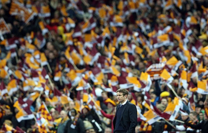 HLV Phil Parkinson lặng lẽ nhìn vào sân trong lúc các khán đài của CĐV Bradford vẫn phấp phới những lá cờ HLV Phil Parkinson lặng lẽ nhìn vào sân trong lúc các khán đài của CĐV Bradford vẫn phấp phới những lá cờ