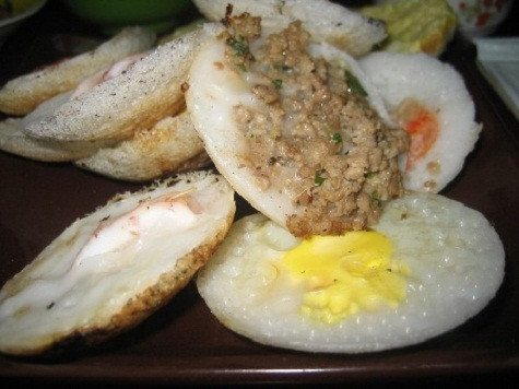 Bánh căn (Ninh Thuận) Nguyên liệu để làm bánh căn là gạo tẻ ngâm khoảng từ 6 đến 8 tiếng đồng hồ rồi đem xay thành bột loãng. Đổ bánh căn dùng một lò đất nung tròn to, bên trên là khuôn bánh được khoét lỗ tròn đều, khuôn đổ bột khoảng 8-16 lỗ; phần thân lò để chứa than hồng. Thoa vào mỗi khuôn một lớp mỡ rồi đậy khuôn, chờ thật nóng mới đổ bột vào. Mẻ đầu được dùng để thử lò và tráng khuôn. Người ta dùng chiếc cạy bằng kim loại để đưa bánh ra khỏi khuôn. Khi mặt trên của bánh căn xốp và khô lại, viền bánh co lại, tróc ra thì bánh đã chín và có thể ăn được. Bánh căn dùng nóng với nước mắm pha chua ngọt, ăn kèm với rau sống, bánh mì chiên giòn. Bánh căn (Ninh Thuận) Nguyên liệu để làm bánh căn là gạo tẻ ngâm khoảng từ 6 đến 8 tiếng đồng hồ rồi đem xay thành bột loãng. Đổ bánh căn dùng một lò đất nung tròn to, bên trên là khuôn bánh được khoét lỗ tròn đều, khuôn đổ bột khoảng 8-16 lỗ; phần thân lò để chứa than hồng. Thoa vào mỗi khuôn một lớp mỡ rồi đậy khuôn, chờ thật nóng mới đổ bột vào. Mẻ đầu được dùng để thử lò và tráng khuôn. Người ta dùng chiếc cạy bằng kim loại để đưa bánh ra khỏi khuôn. Khi mặt trên của bánh căn xốp và khô lại, viền bánh co lại, tróc ra thì bánh đã chín và có thể ăn được. Bánh căn dùng nóng với nước mắm pha chua ngọt, ăn kèm với rau sống, bánh mì chiên giòn.