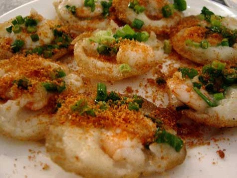 Bánh căn (Ninh Thuận) Nguyên liệu để làm bánh căn là gạo tẻ ngâm khoảng từ 6 đến 8 tiếng đồng hồ rồi đem xay thành bột loãng. Đổ bánh căn dùng một lò đất nung tròn to, bên trên là khuôn bánh được khoét lỗ tròn đều, khuôn đổ bột khoảng 8-16 lỗ; phần thân lò để chứa than hồng. Thoa vào mỗi khuôn một lớp mỡ rồi đậy khuôn, chờ thật nóng mới đổ bột vào. Mẻ đầu được dùng để thử lò và tráng khuôn. Người ta dùng chiếc cạy bằng kim loại để đưa bánh ra khỏi khuôn. Khi mặt trên của bánh căn xốp và khô lại, viền bánh co lại, tróc ra thì bánh đã chín và có thể ăn được. Bánh căn dùng nóng với nước mắm pha chua ngọt, ăn kèm với rau sống, bánh mì chiên giòn. Bánh căn (Ninh Thuận) Nguyên liệu để làm bánh căn là gạo tẻ ngâm khoảng từ 6 đến 8 tiếng đồng hồ rồi đem xay thành bột loãng. Đổ bánh căn dùng một lò đất nung tròn to, bên trên là khuôn bánh được khoét lỗ tròn đều, khuôn đổ bột khoảng 8-16 lỗ; phần thân lò để chứa than hồng. Thoa vào mỗi khuôn một lớp mỡ rồi đậy khuôn, chờ thật nóng mới đổ bột vào. Mẻ đầu được dùng để thử lò và tráng khuôn. Người ta dùng chiếc cạy bằng kim loại để đưa bánh ra khỏi khuôn. Khi mặt trên của bánh căn xốp và khô lại, viền bánh co lại, tróc ra thì bánh đã chín và có thể ăn được. Bánh căn dùng nóng với nước mắm pha chua ngọt, ăn kèm với rau sống, bánh mì chiên giòn.