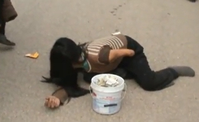 Mặc dù đang "bận" với "bài" khóc để... lừa gạt mọi người, ăn mày này vẫn nghe ngóng tình hình công an