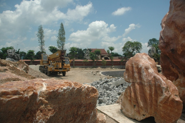 Để làm nên các hòn non bộ phải cần đến sự trợ giúp của máy cẩu (phía xa) Để làm nên các hòn non bộ phải cần đến sự trợ giúp của máy cẩu (phía xa)