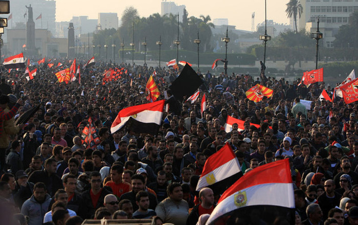 Một người khác có một tấm băng quanh miệng với dòng chữ “Cuộc cách mạng sẽ tiếp tục”. Một người khác có một tấm băng quanh miệng với dòng chữ “Cuộc cách mạng sẽ tiếp tục”.