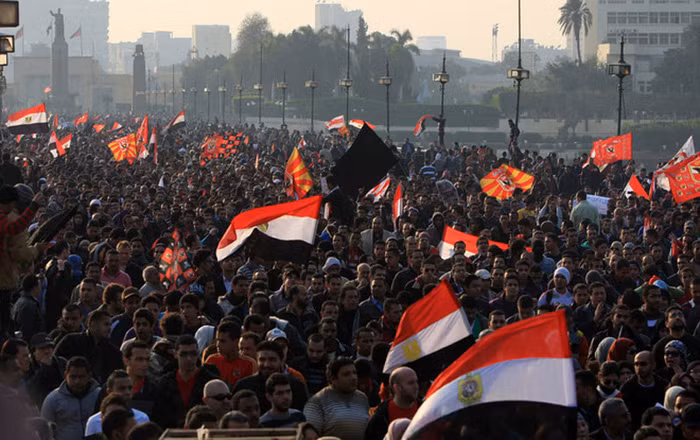 Một người khác có một tấm băng quanh miệng với dòng chữ “Cuộc cách mạng sẽ tiếp tục”.