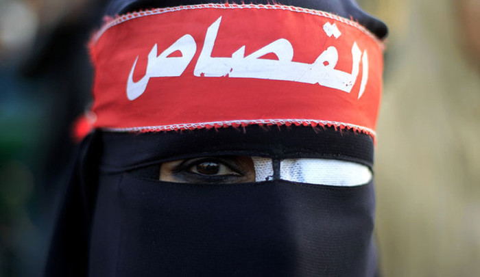 Một người phụ nữ Ai Cập đeo một miếng vá mắt cùng tấm băng đầu có dòng chữ “trừng phạt” Một người phụ nữ Ai Cập đeo một miếng vá mắt cùng tấm băng đầu có dòng chữ “trừng phạt”