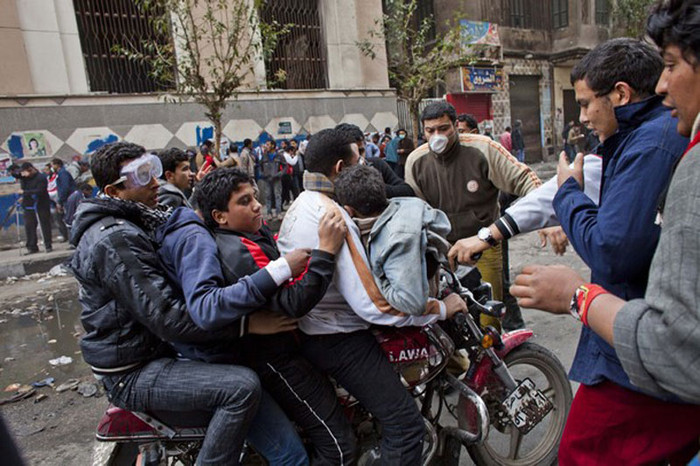 Một người đàn ông dùng xe máy chở một lúc 4 người biểu tình khác bị nhiễm hơi cay tới bệnh viện. Xe cứu thương vẫn không thể vào được do bị chướng ngại vật ngăn cản Một người đàn ông dùng xe máy chở một lúc 4 người biểu tình khác bị nhiễm hơi cay tới bệnh viện. Xe cứu thương vẫn không thể vào được do bị chướng ngại vật ngăn cản