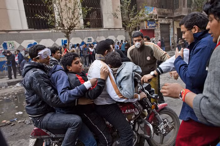 Một người đàn ông dùng xe máy chở một lúc 4 người biểu tình khác bị nhiễm hơi cay tới bệnh viện. Xe cứu thương vẫn không thể vào được do bị chướng ngại vật ngăn cản