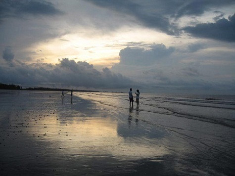 Những đôi lứa yêu nhau tận hưởng vẻ đẹp của bình minh trên biển