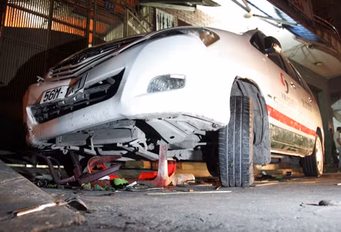 Taxi cuốn bé gái và bàn ghế dưới gầm xe. Ảnh: An Nhơn Taxi cuốn bé gái và bàn ghế dưới gầm xe. Ảnh: An Nhơn