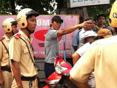 Đối tượng Thương (áo thun sọc) bị bắt vì chống người thi hành công vụ (Ảnh: Người Lao Động)