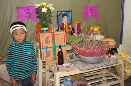 Cháu Tiến bên bàn thờ bố. Cháu Tiến bên bàn thờ bố.