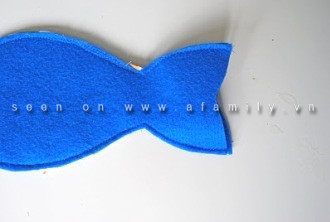 Đặt 2 miếng hình cá như trùng khít nhau, mặt phải úp vào nhau, may 1 đường bao quanh chúng, may gần sát mép vải, chừa lại phần ngoài cùng của đuôi cá: Đặt 2 miếng hình cá như trùng khít nhau, mặt phải úp vào nhau, may 1 đường bao quanh chúng, may gần sát mép vải, chừa lại phần ngoài cùng của đuôi cá: