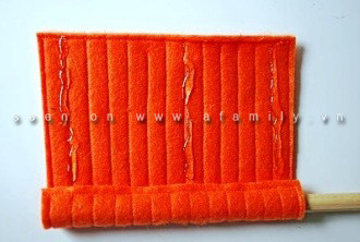 Bôi keo và vừa cuộn vừa dán miếng vải to vào cán cần câu. Bôi keo và vừa cuộn vừa dán miếng vải to vào cán cần câu.