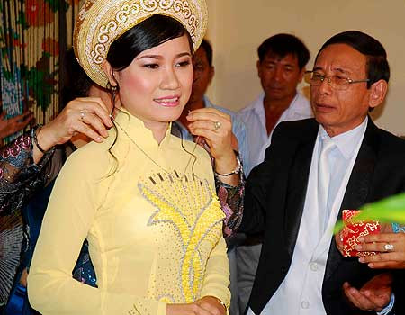 Mẹ vợ tương lai lão đại gia đeo trang sức sính lễ cho con gái trong ngày ăn hỏi. Ảnh: Xuân Trường. Mẹ vợ tương lai lão đại gia đeo trang sức sính lễ cho con gái trong ngày ăn hỏi. Ảnh: Xuân Trường.