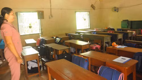 Theo hướng dẫn của cô giáo, học sinh lớp 1 Trường tiểu học Bình Thạnh phải núp dưới gầm bàn mỗi khi trời mưa để được an toàn