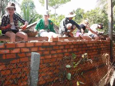 Nữ sinh 15 tuổi Alexandra Barlon (bên trái) làm thợ xây.
