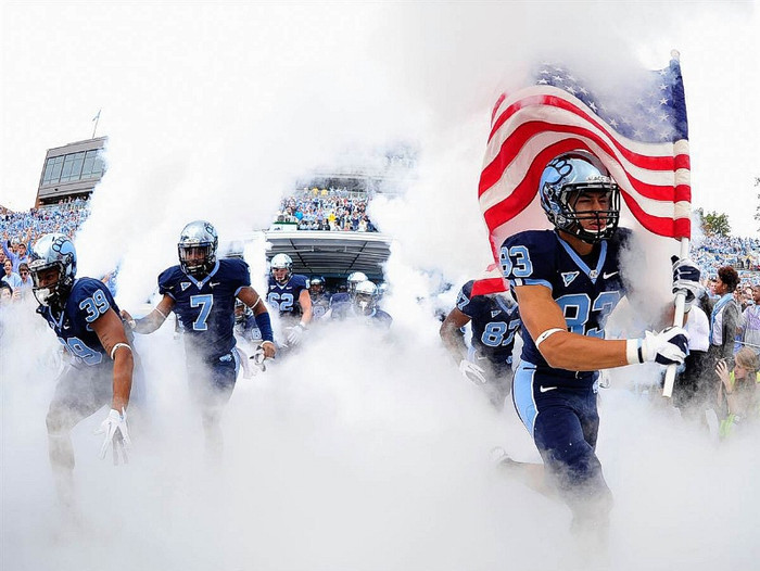 Các cầu thủ đội bóng bầu dục trường đại học Bắc Carolina bước ra sân trước trận đấu với kình địch cùng bang, trường đại học Bang Bắc Carolina.