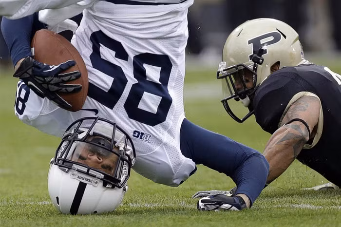 Brandon Moseby-Felder của đội Penn State cắm đầu xuống đất sau khi nhảy lên bắt bóng và bị cản phá bởi Ricardo Allen của đội Purdue.