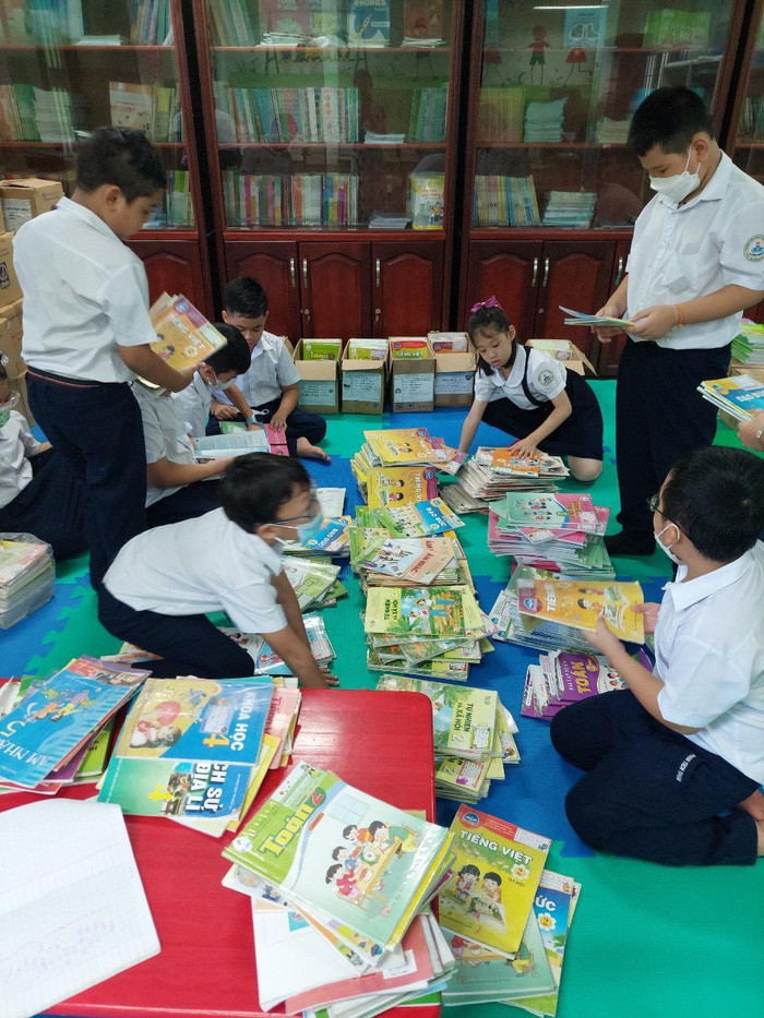 Các em học sinh sửa sang, phân loại sách theo bộ/lớp Các em học sinh sửa sang, phân loại sách theo bộ/lớp