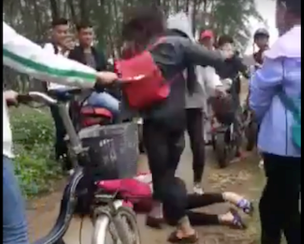 Nữ sinh bị nhóm bạn đấm, đá túi bụi khiến nạn nhân nằm gục xuống đất (ảnh cắt từ clip)