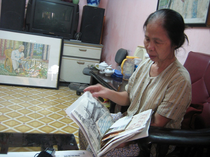 Bà Phạm Thị Uyển đang lần giở lại những con tem mình đã sưu tầm để chuẩn bị cho những bức ghép tranh Bác Hồ.