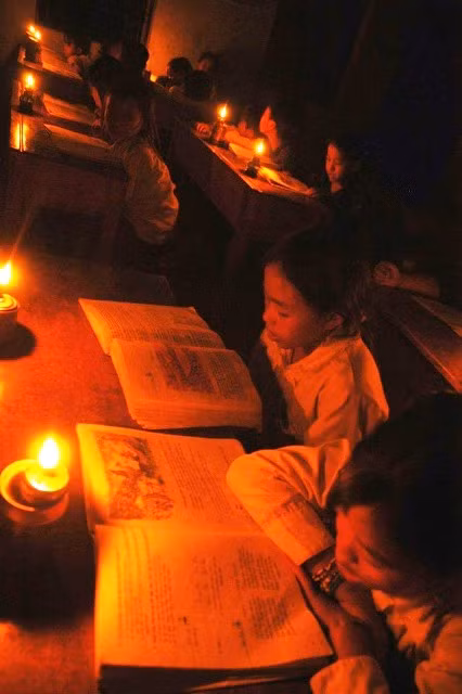 Dưới ánh đèn dầu tù mù nhưng các em học rất nghiêm túc, không kém gì lớp học ban ngày.