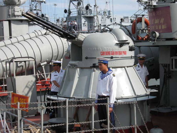 Thủy thủ hải quân nhân dân Việt Nam bên cạnh pháo hạm 37 li của tàu HQ 355, Hải đội 132, Lữ đoàn 172, Vùng C Hải Quân.